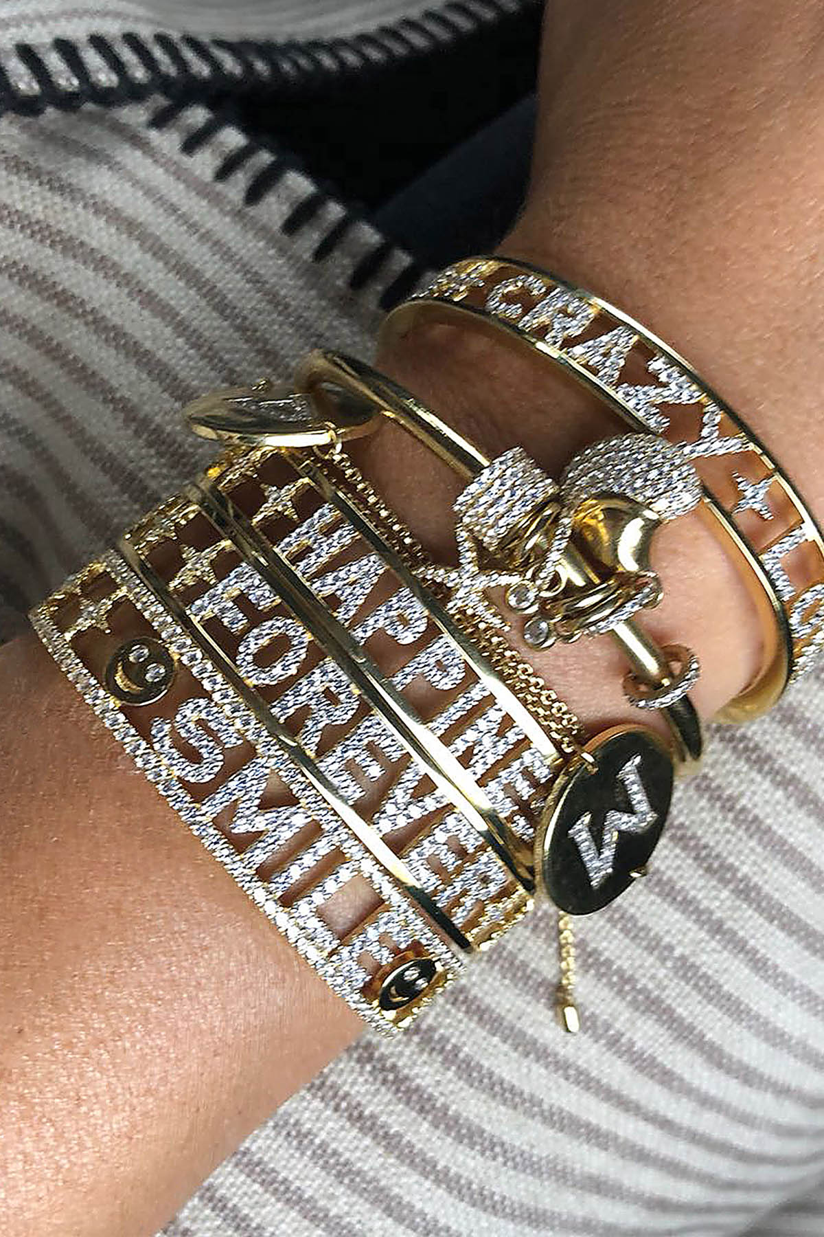Femme portant un stack de bracelets APM, éclat doré et messages lumineux au poignet.