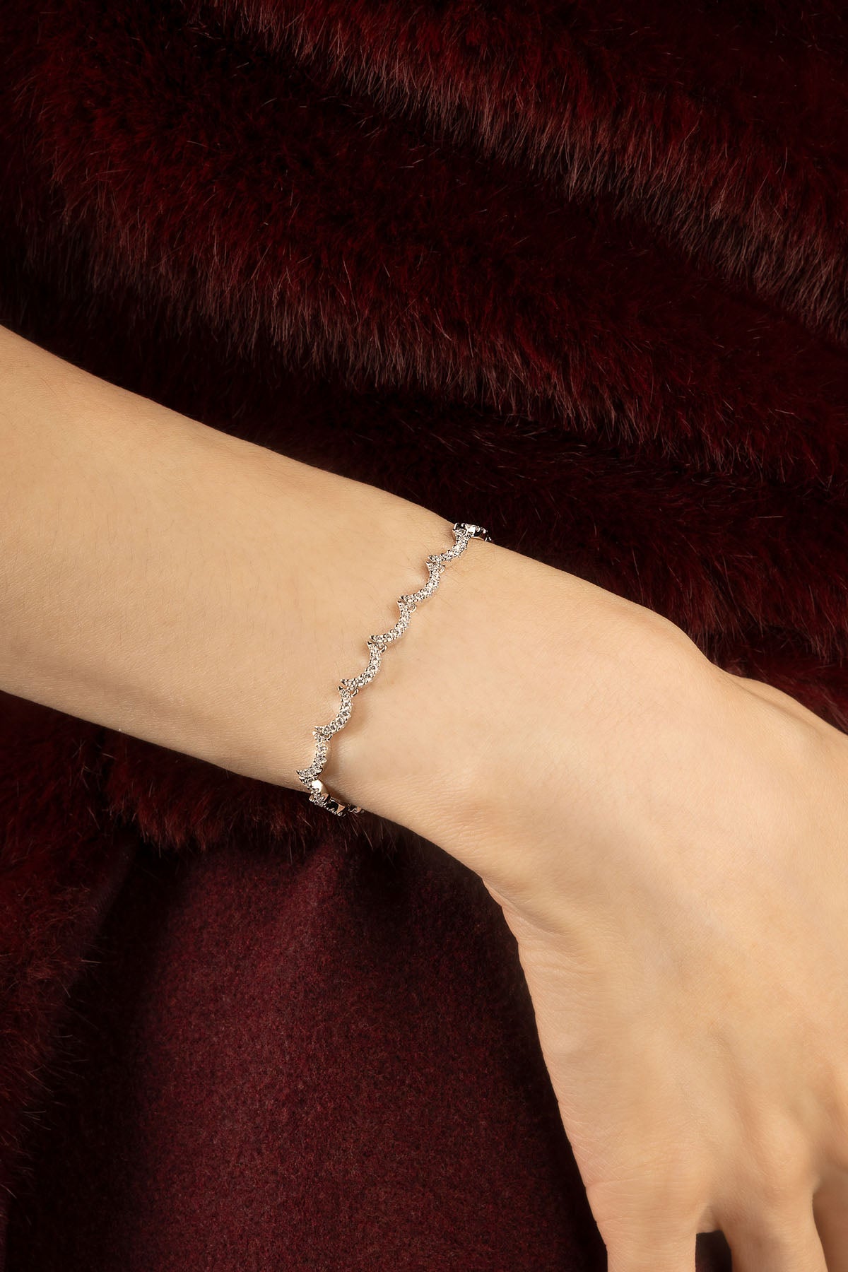 Femme portant le bracelet APM, une ondulation scintillante posée sur la peau.