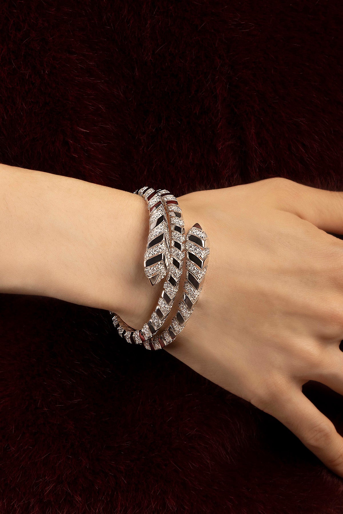 Woman wearing APM bracelet Plume, une spirale scintillante d'une élégance contemporaine.