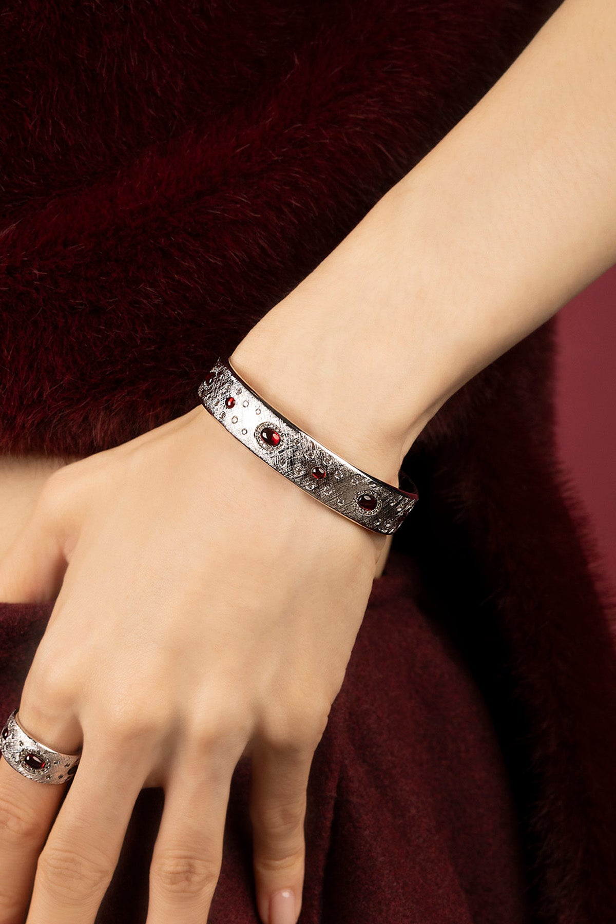 Femme portant le Bracelet APM Monaco, éclats rouges sur finition rhodium, allure envoûtante.