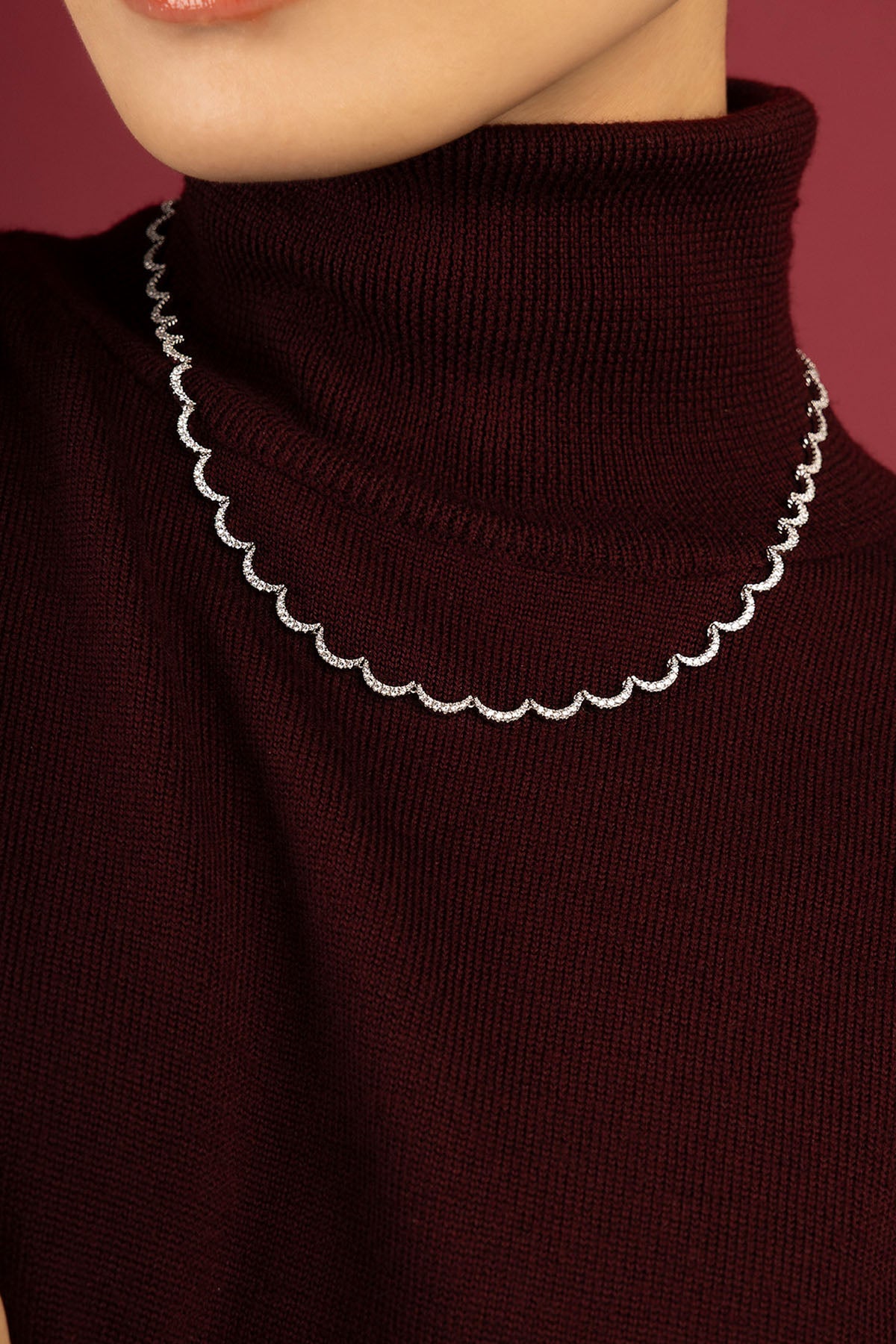Femme portant le collier APM, une ondulation scintillante pour une allure hivernale raffinée.