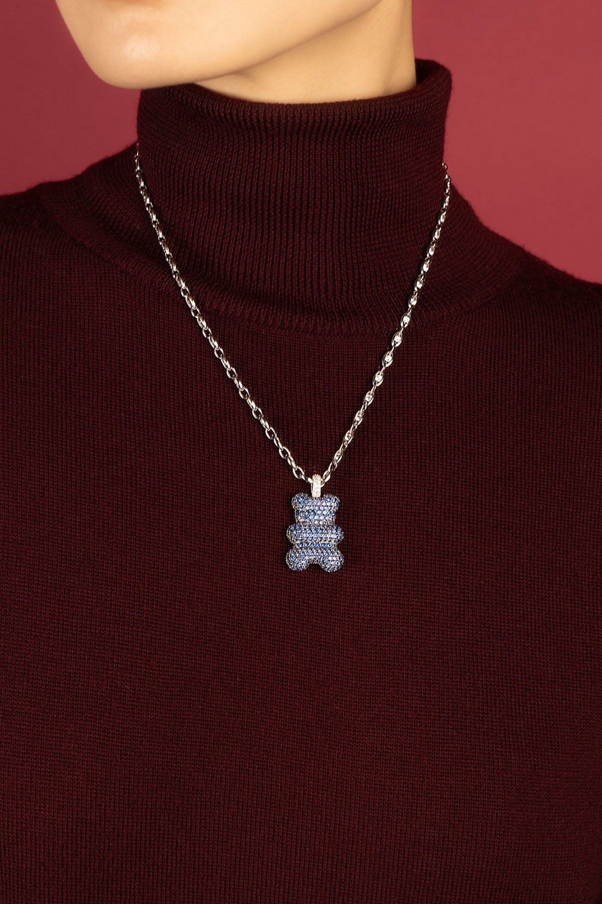 Femme portant le Collier Yummy Bear APM, une touche bleue pleine de douceur hivernale.