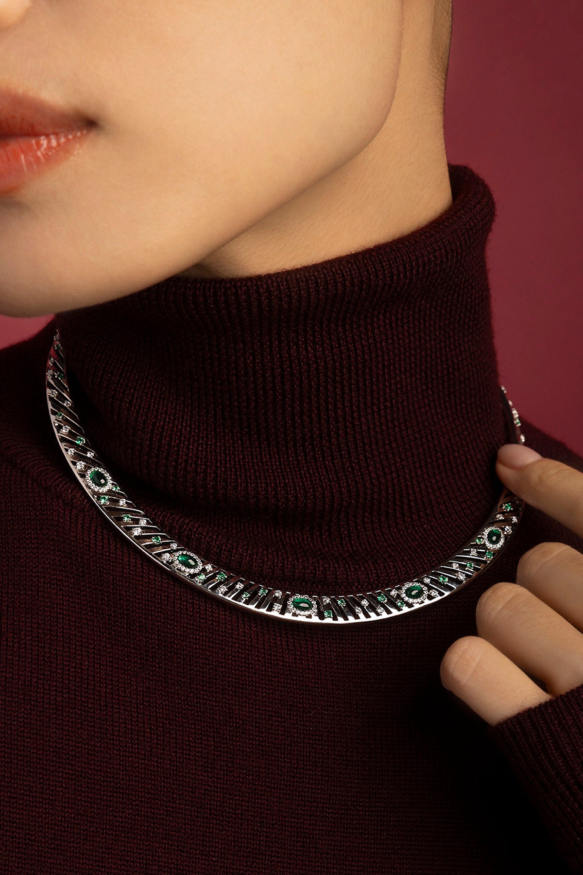 Femme portant le collier APM, éclats verts et allure sculpturale pour une élégance affirmée.