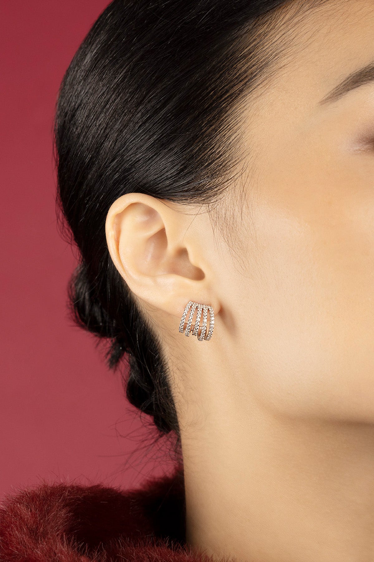 Femme portant les boucles d'oreilles APM, éclat multi-arches pour une allure moderne et raffinée.