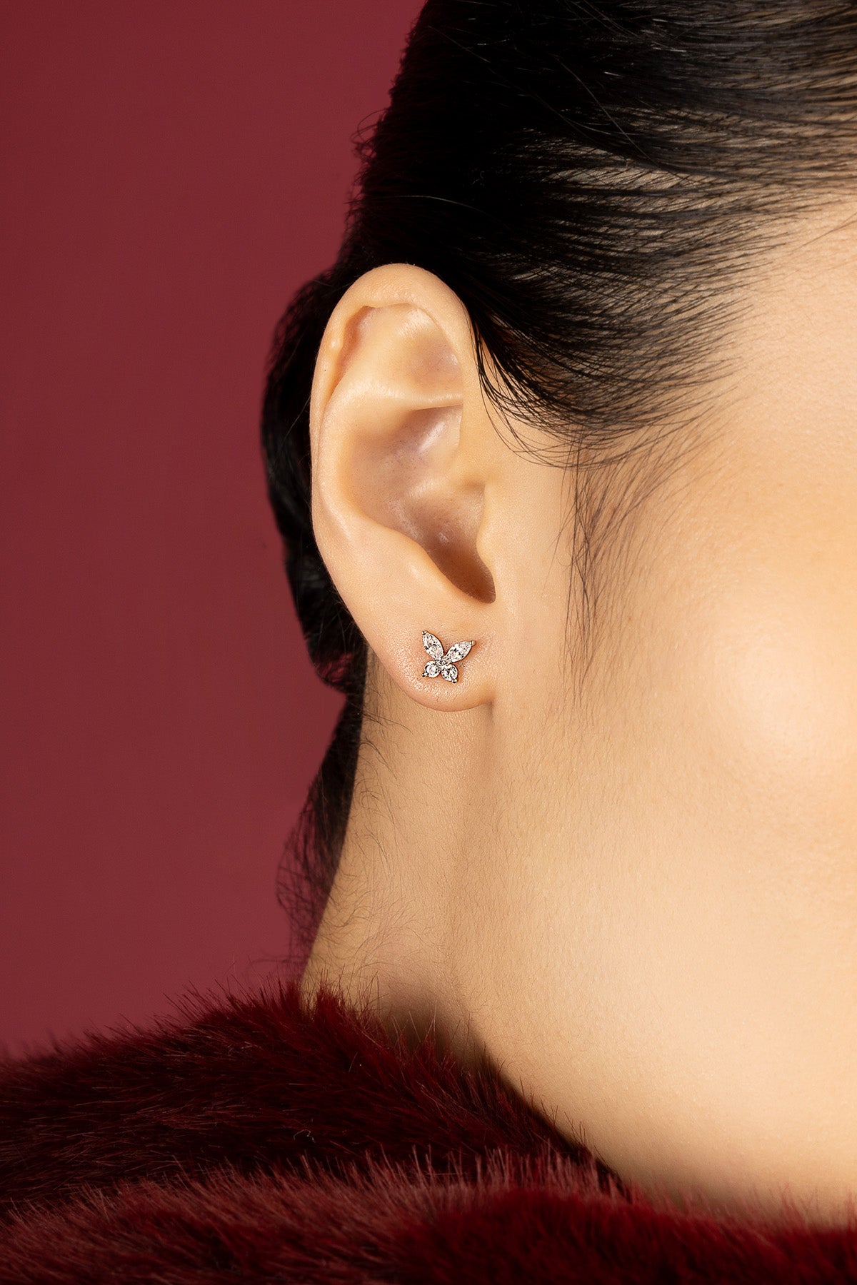 Femme portant les boucles d'oreilles papillon APM Monaco, une envolée délicate et scintillante.