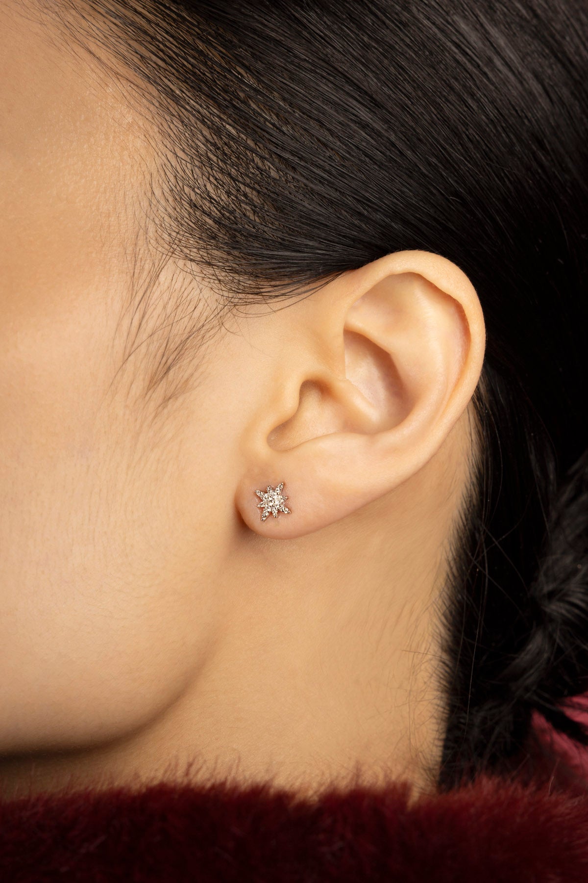 Femme portant les Boucles d'Oreilles Étoile APM, une étincelle délicate au creux de l'oreille.