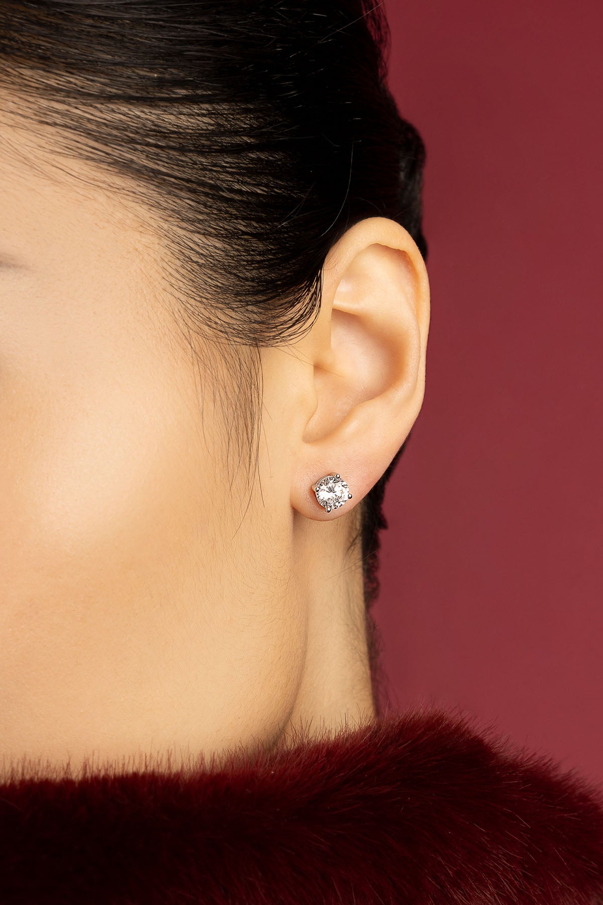 Woman wearing APM puces d'oreilles, éclat solitaire d'une élégance intemporelle.