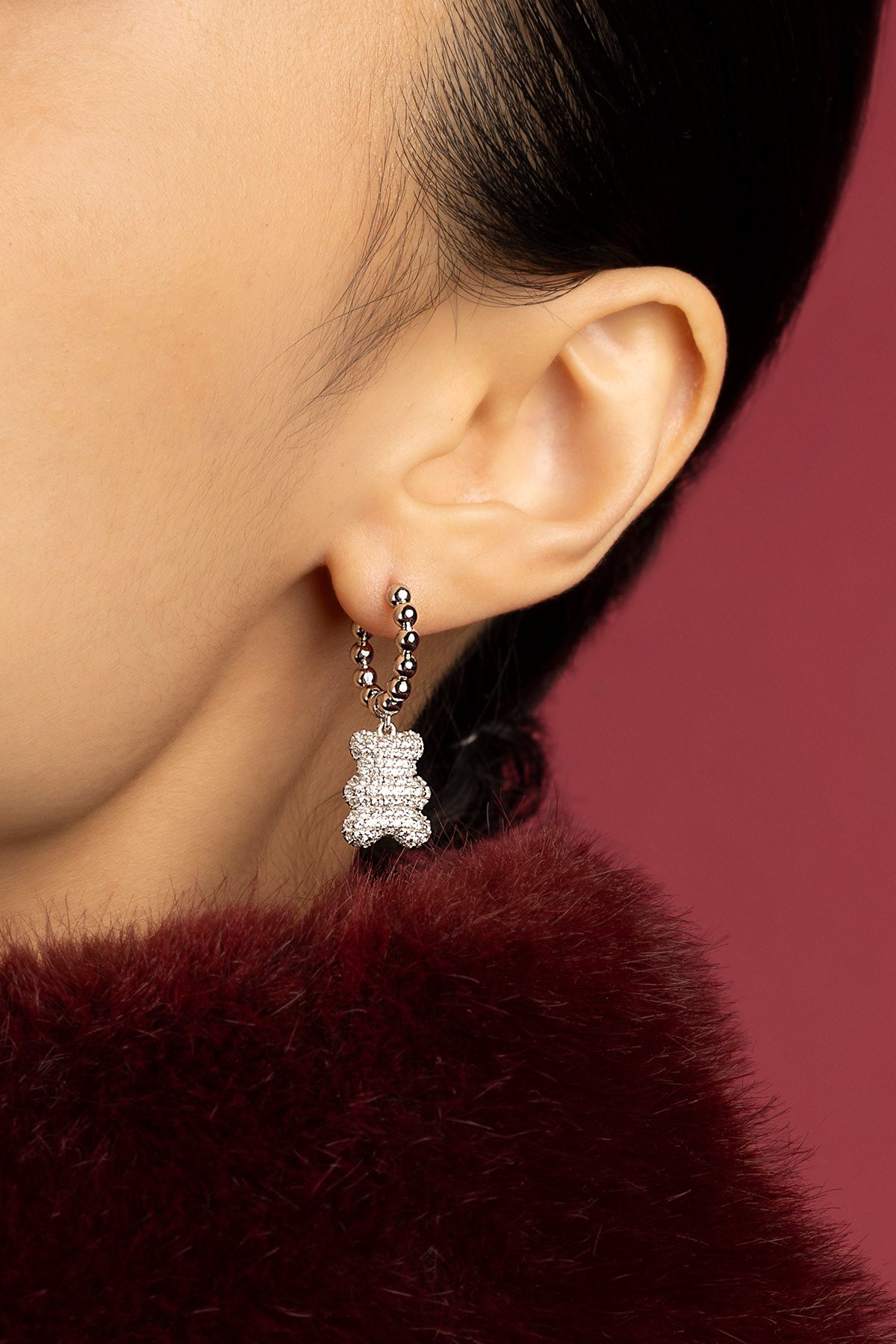 Femme portant les APM boucles d'oreilles Yummy Bear, douceur scintillante et allure hivernale.