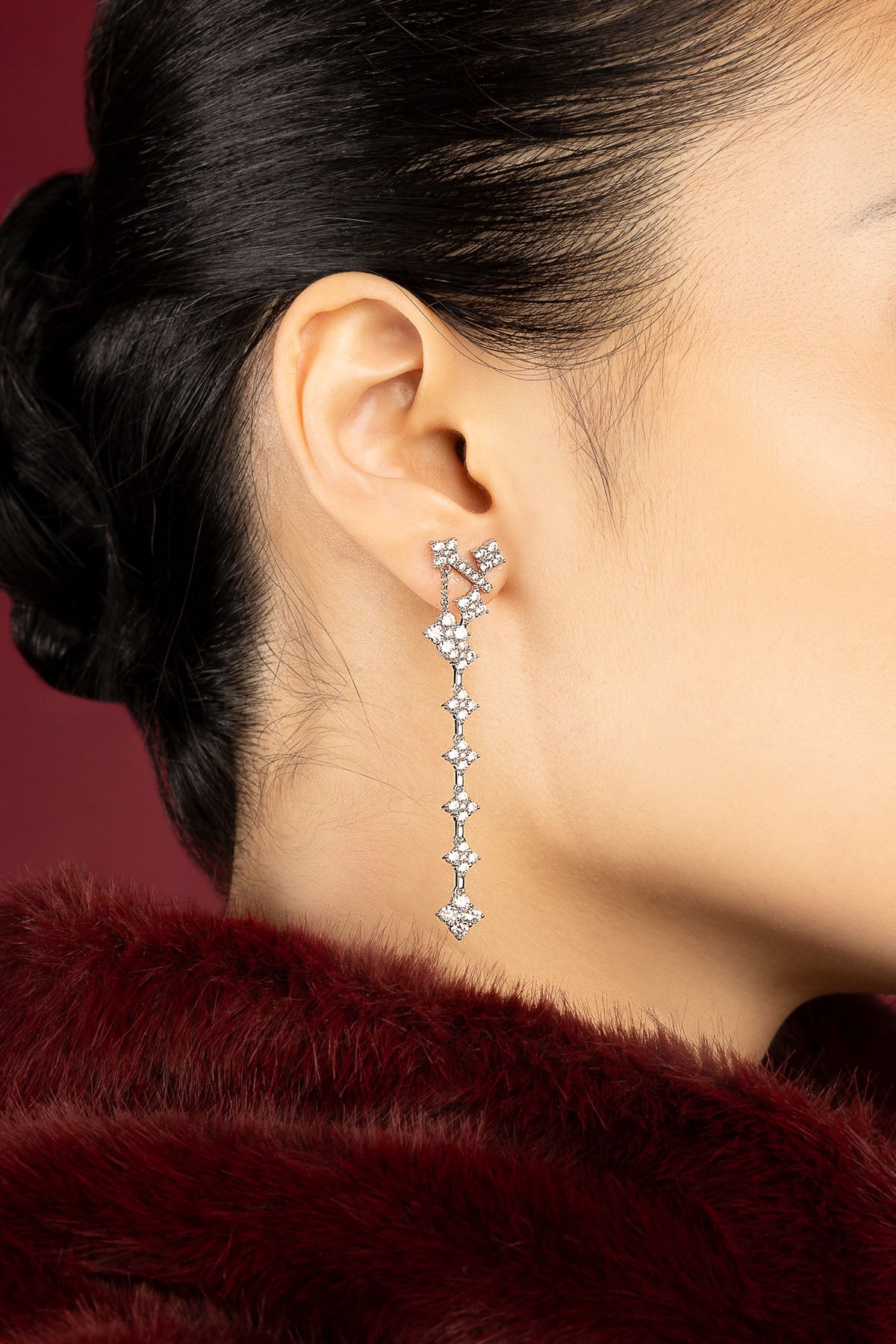 Femme portant les boucles d'oreilles pendantes APM, une cascade lumineuse d'élégance intemporelle.