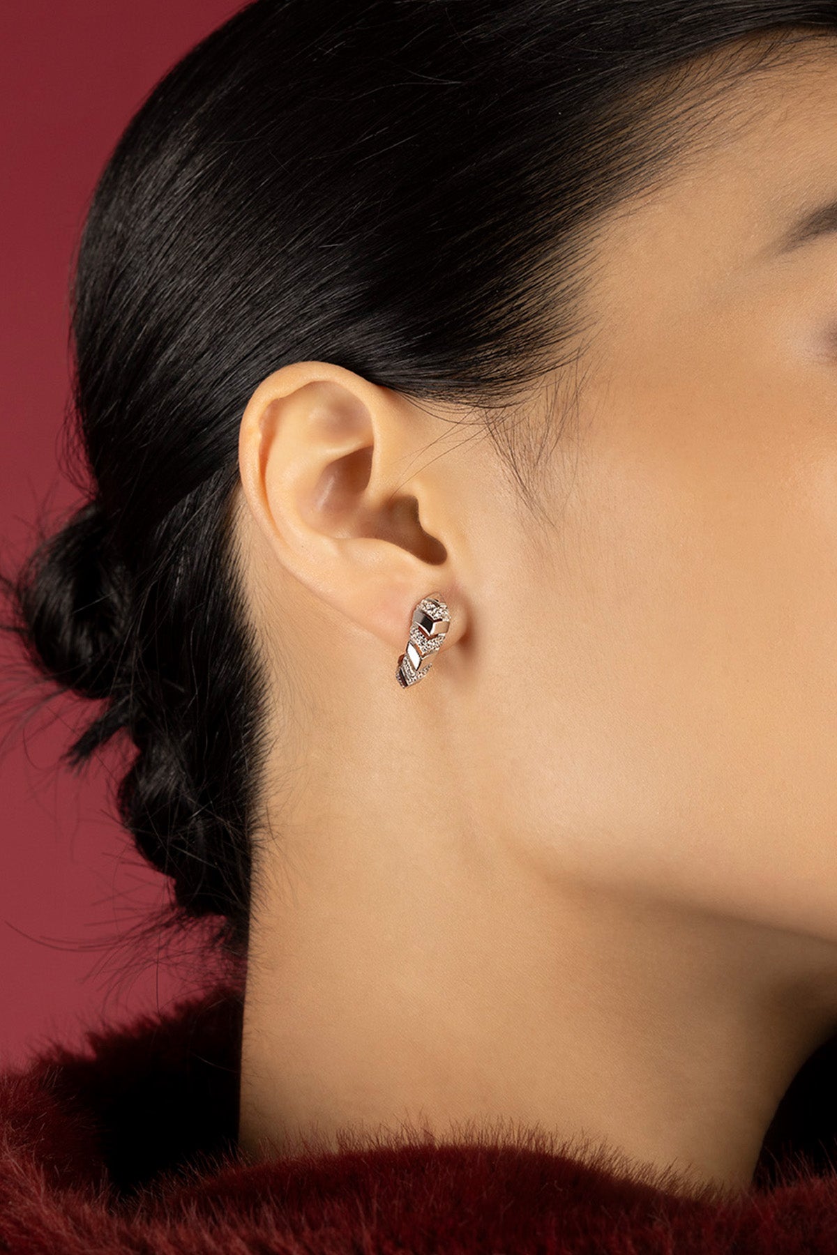 Femme portant les boucles d'oreilles APM, éclat tressé et allure résolument moderne.