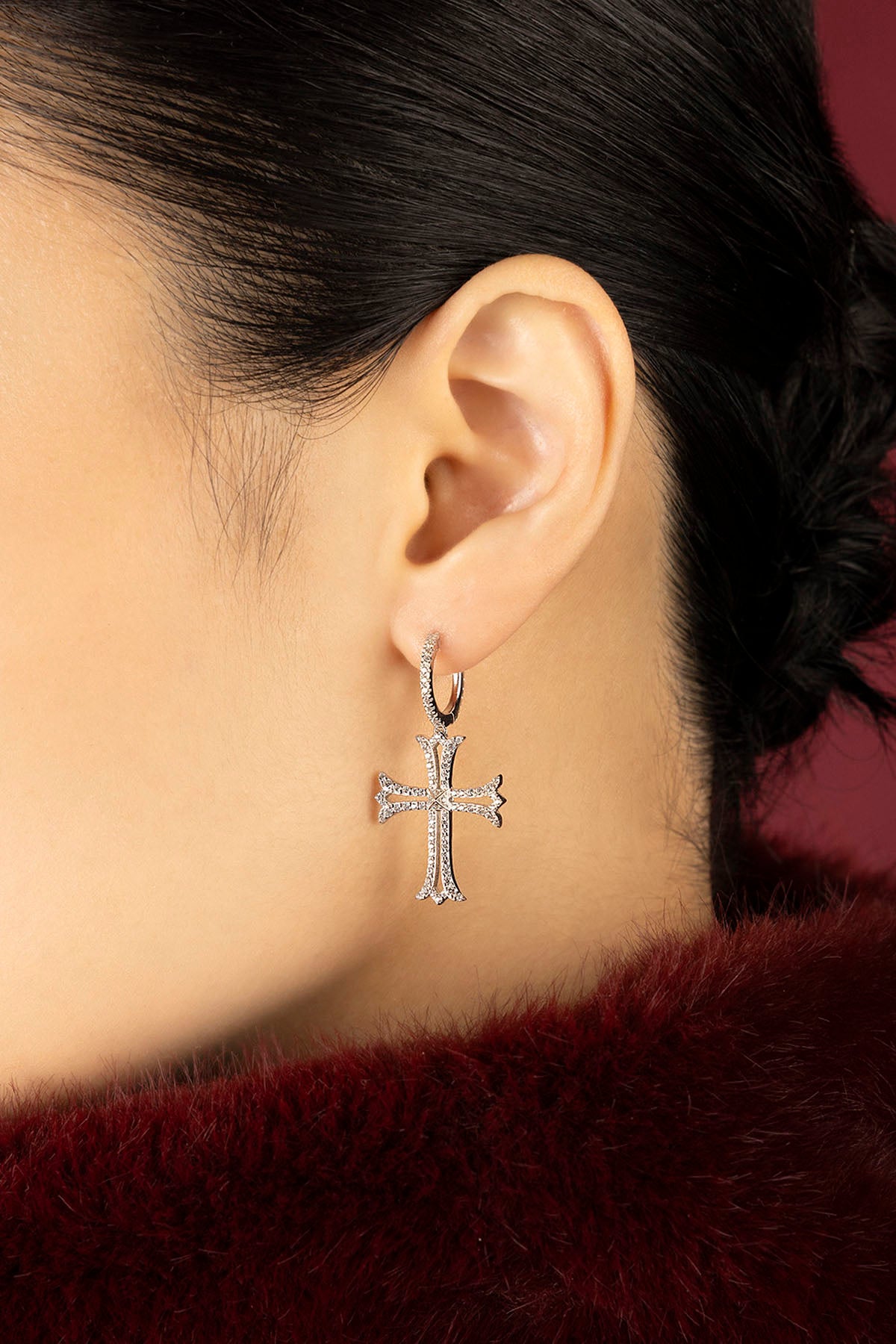 Femme portant les boucles d'oreilles croix APM, une allure gothique et lumineuse.