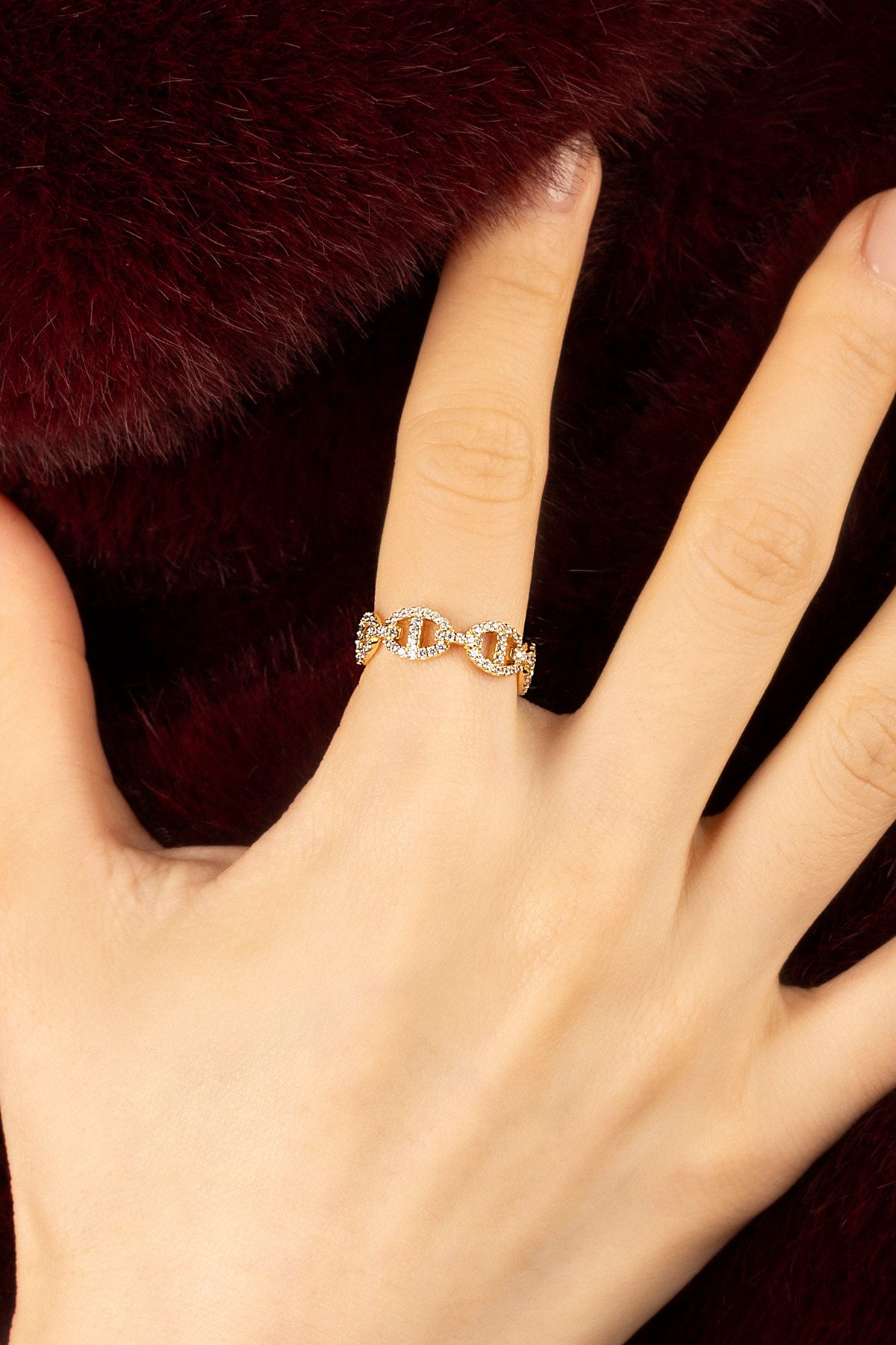 Femme portant la Morse Ring APM, éclat doré et allure féline sur fourrure bordeaux.