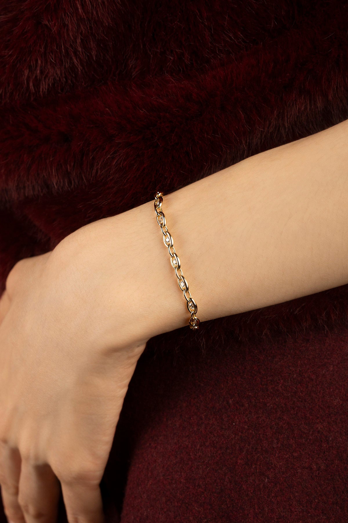 Femme portant le bracelet APM Monaco, une chaîne dorée délicate à l'éclat chaleureux.