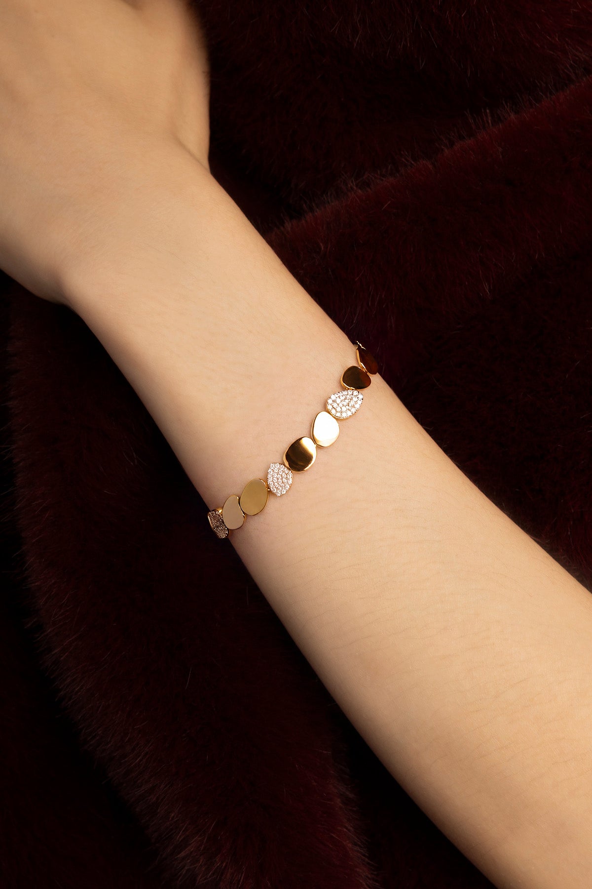 Femme portant le Bracelet APM Monaco, une cascade de galets dorés, éclat feutré et moderne.