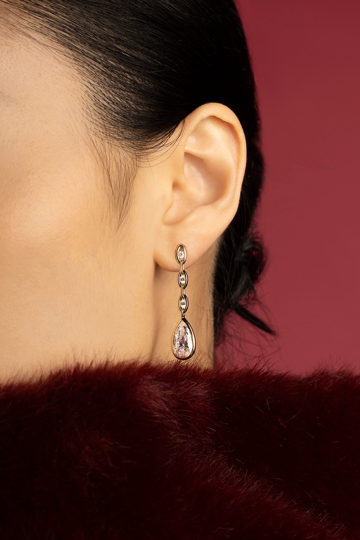 Femme portant les boucles d'oreilles pendantes APM, une élégance goutte à goutte irrésistible.