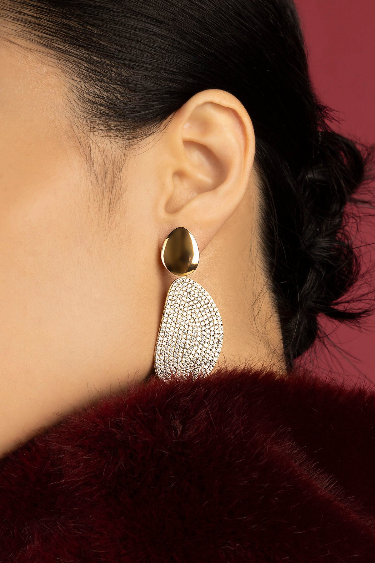 Woman wearing APM boucles d'oreilles, éclat doré et allure sculpturale.