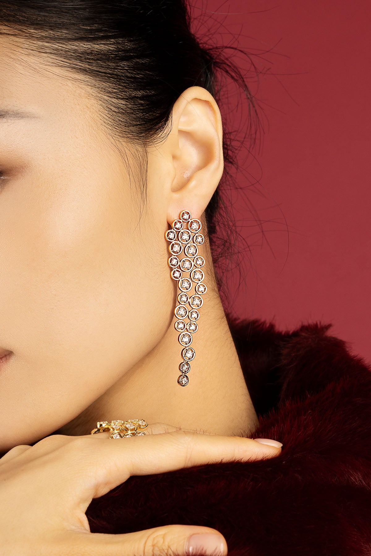 Femme portant les boucles d'oreilles APM, une cascade lumineuse d'élégance intemporelle.