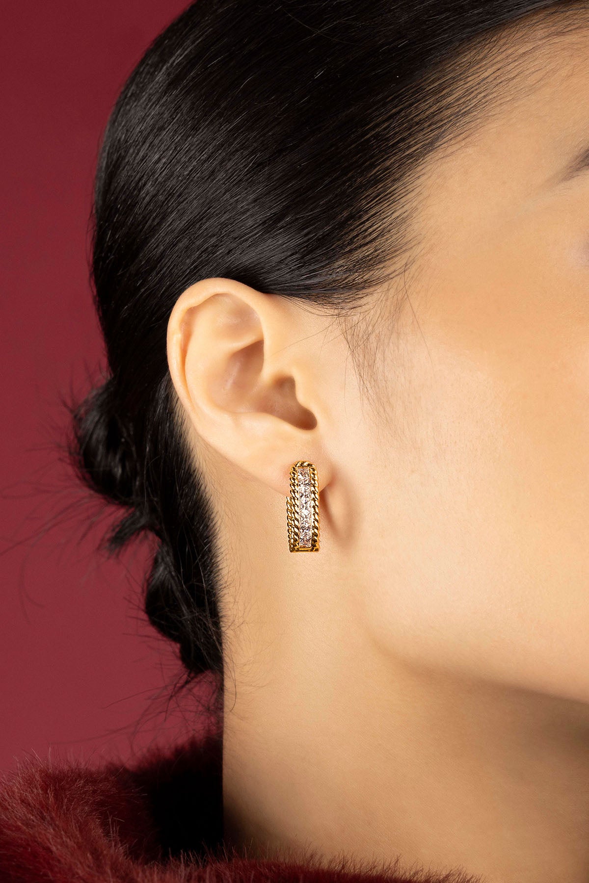 Woman wearing APM boucles d'oreilles, une élégance dorée aux reflets scintillants.