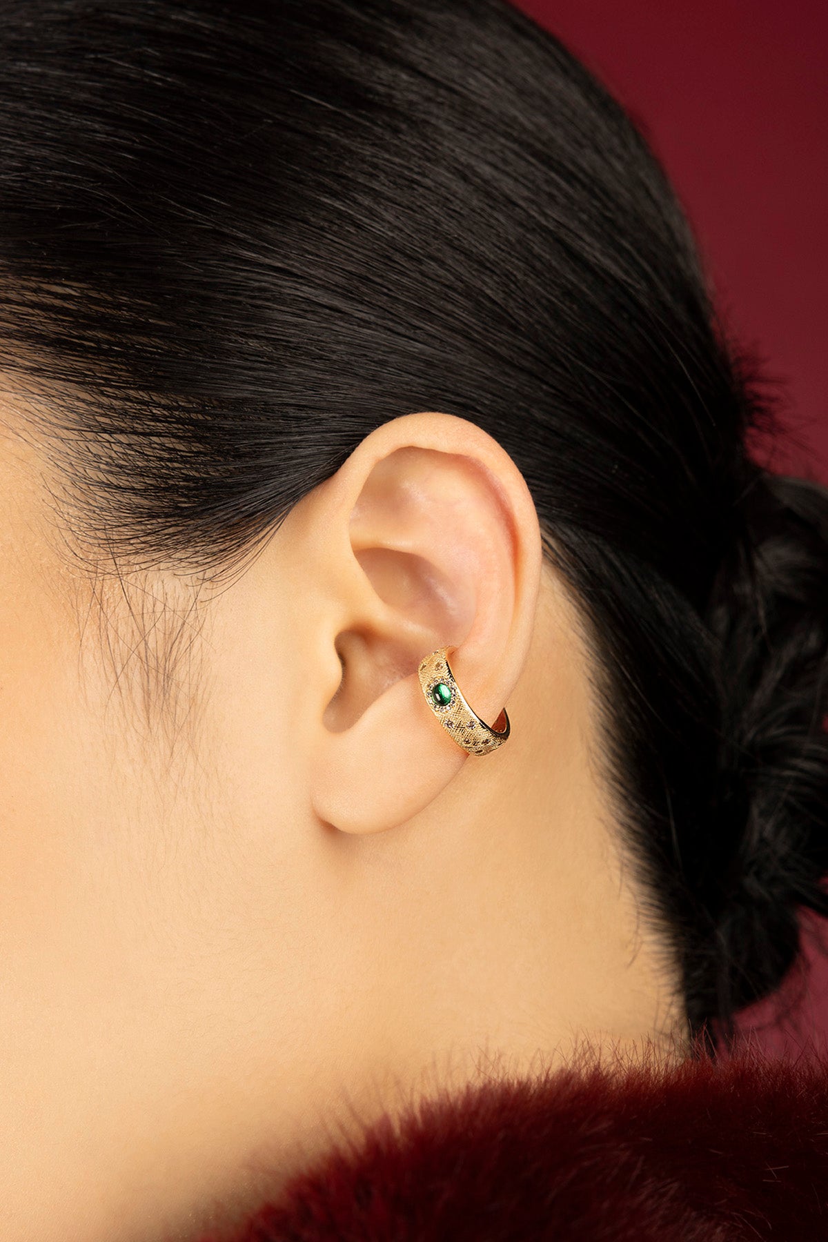 Femme portant une APM ear cuff dorée, une touche précieuse et audacieuse.