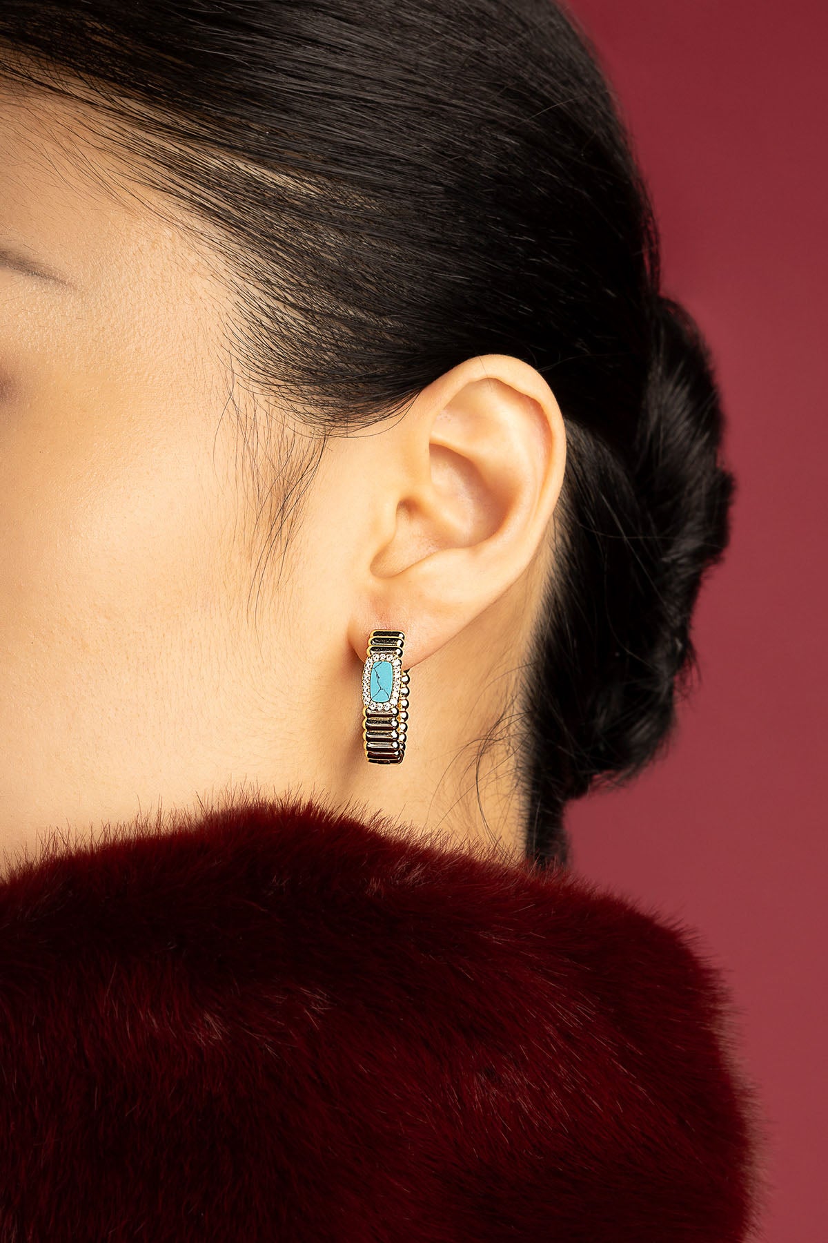 Femme portant les Boucles d'oreilles APM, une touche turquoise pour une élégance intemporelle.