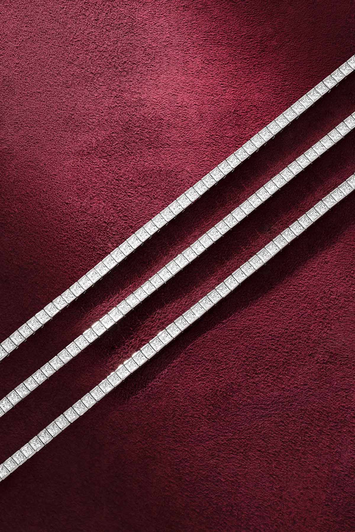 Bracelets tennis APM, une ligne scintillante et intemporelle sur velours bordeaux.