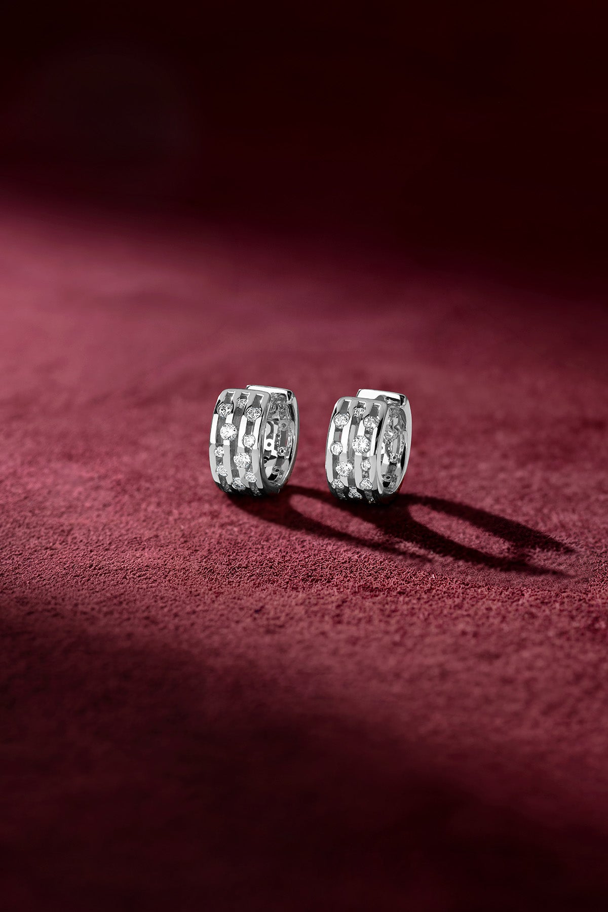 Créoles APM Monaco au rhodium finish, une élégance scintillante posée sur velours.