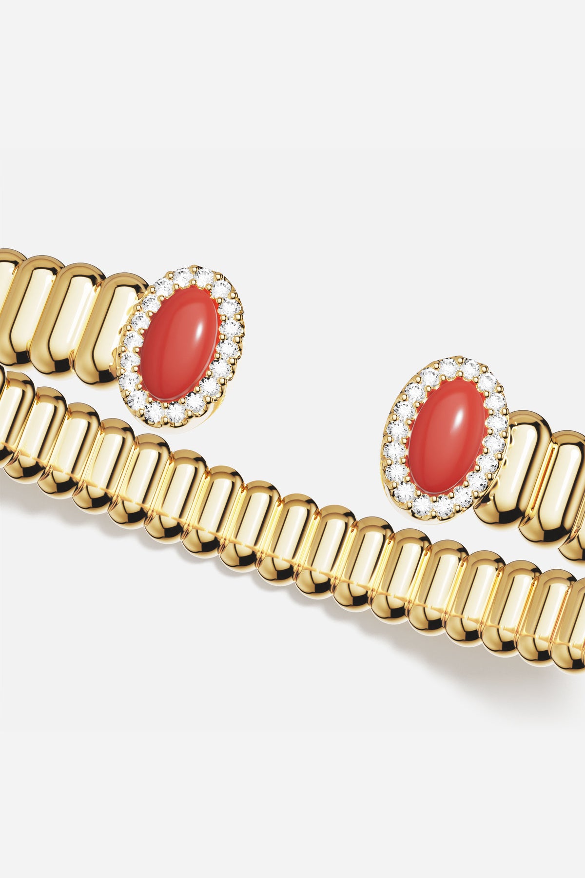 Bracelet APM ouvert doré, cabochons rouges éclatants, une allure précieuse et solaire.