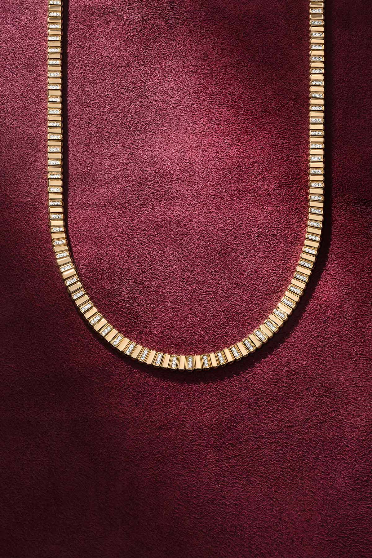 Collier APM, maillons scintillants aux reflets dorés, une élégance moderne et lumineuse.