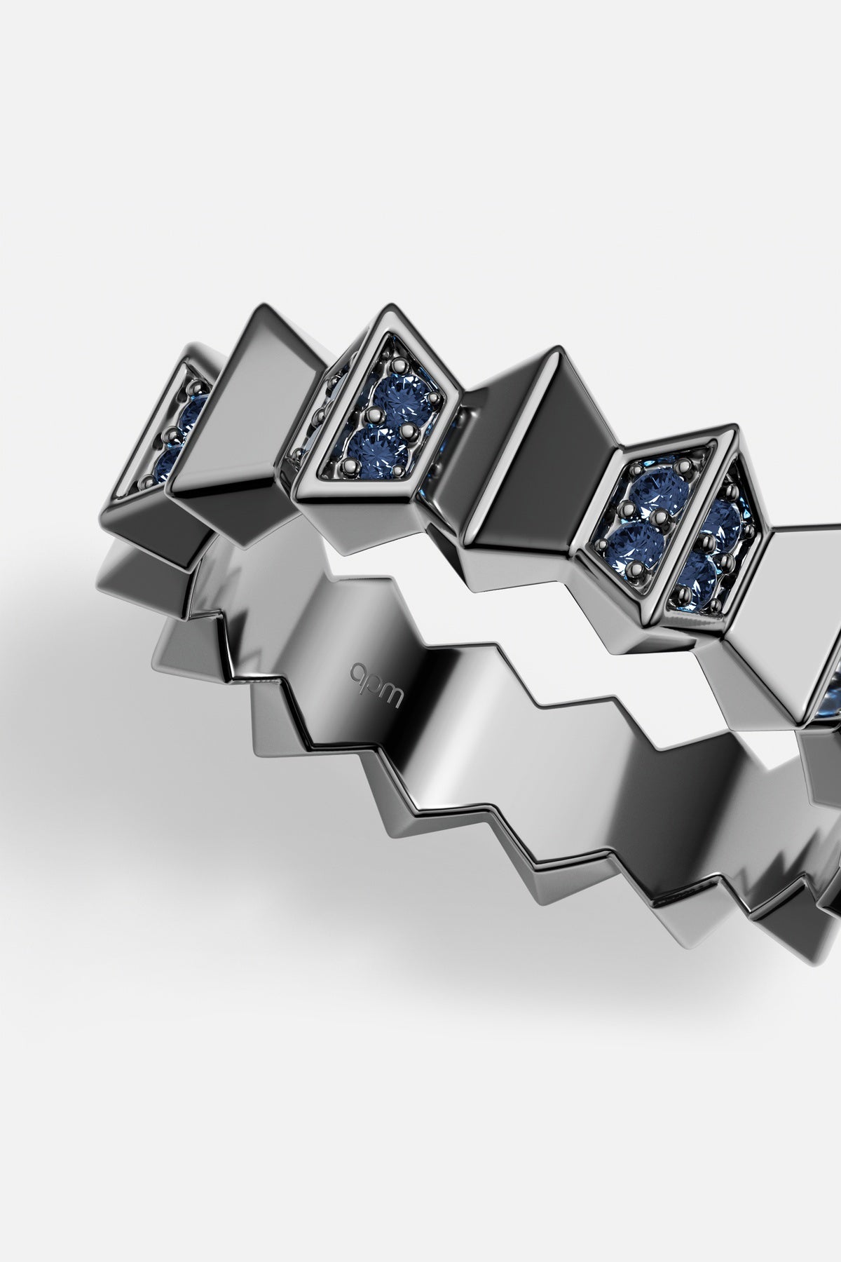 Bague APM Monaco au relief zigzag audacieux, rehaussée de pierres bleues profondes, allure résolument moderne.