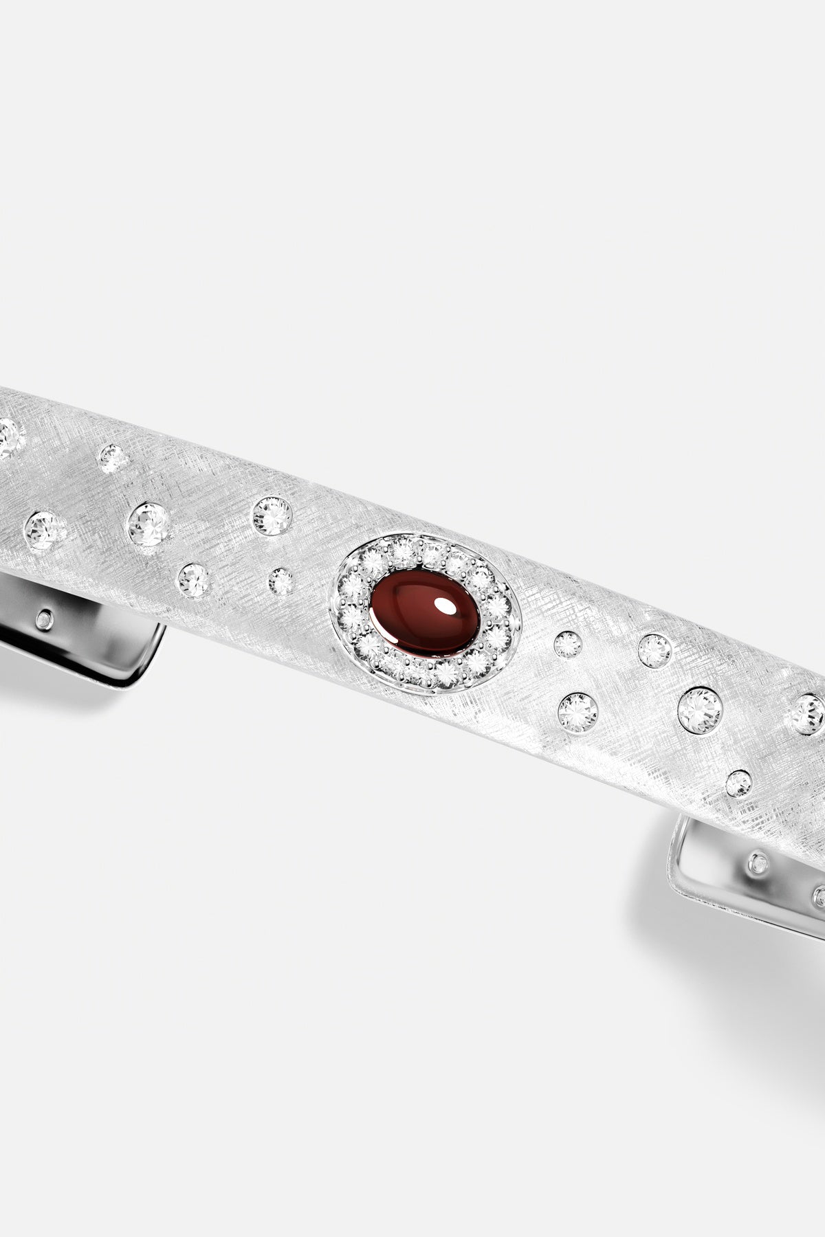 Barrette APM, finition rhodium étoilée et cabochon rouge profond, élégance intemporelle.