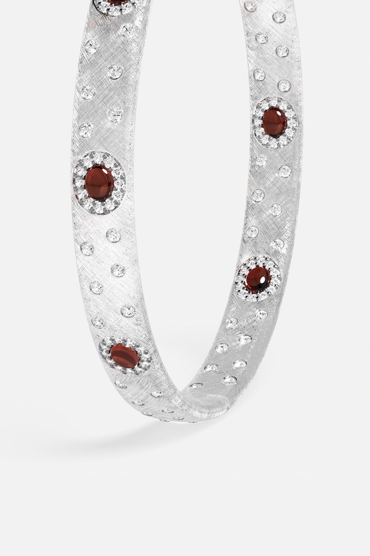 Bracelet APM au fini rhodium, éclats scintillants et pierres rouges profondes, allure précieuse et audacieuse.