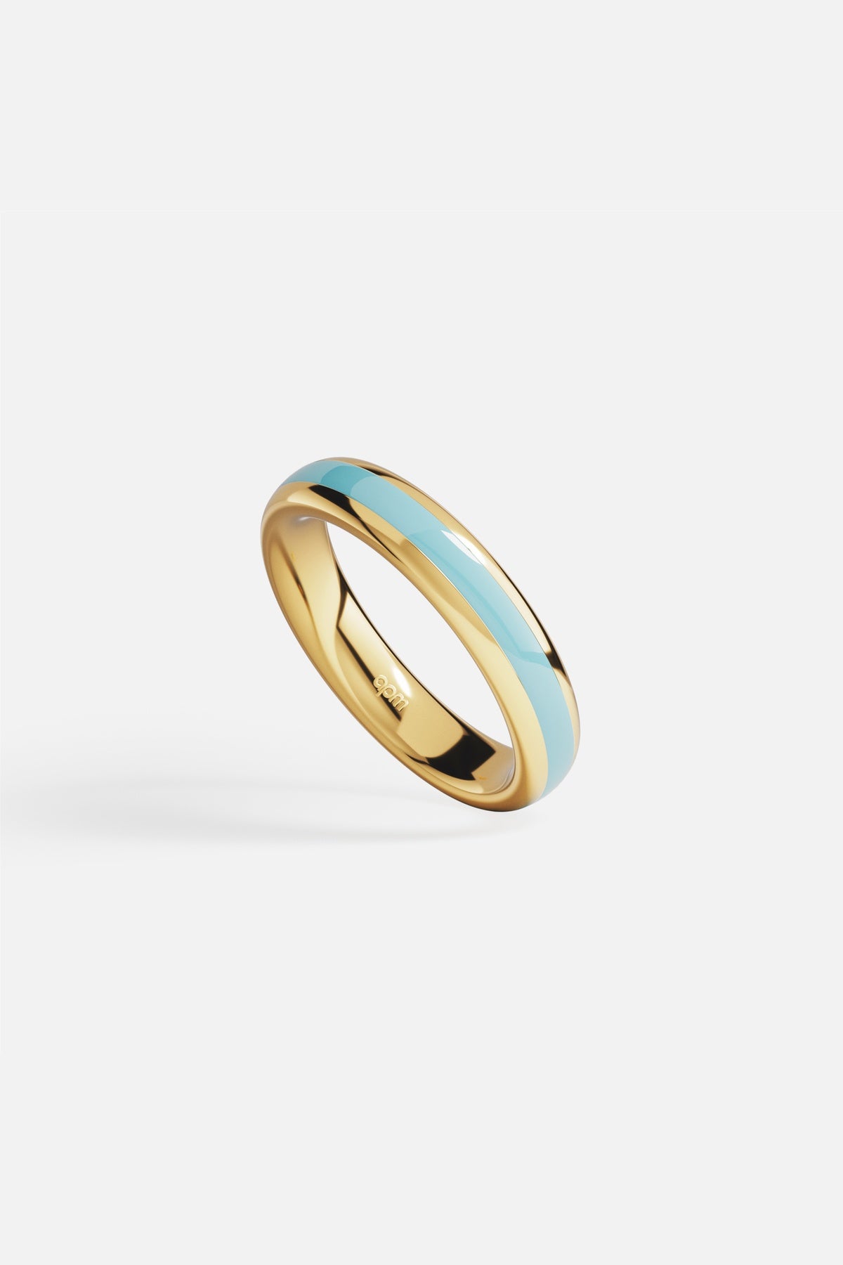 Bague APM couleur dorée, une ligne bleu ciel, douceur contemporaine au bout des doigts.