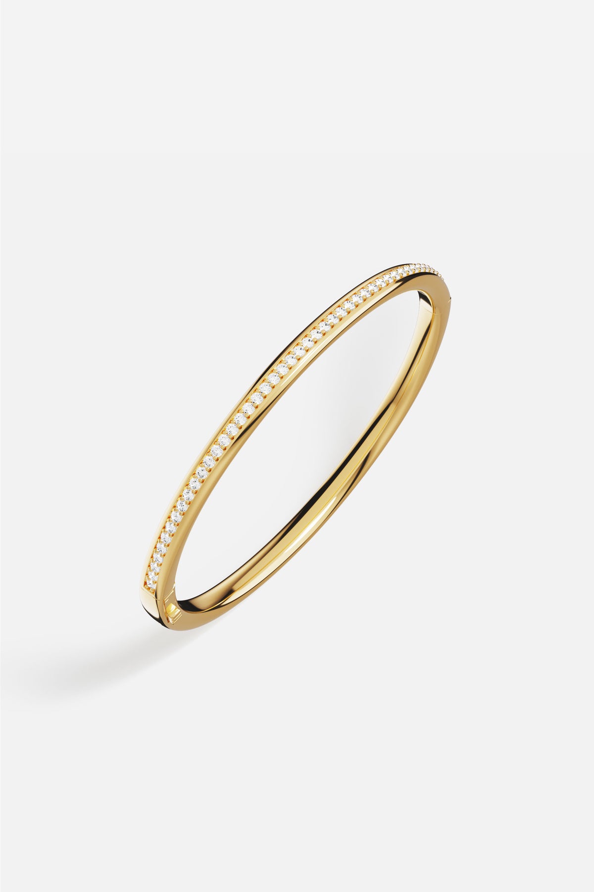 Bracelet jonc APM, ligne dorée épurée et éclat scintillant, pour une élégance intemporelle.