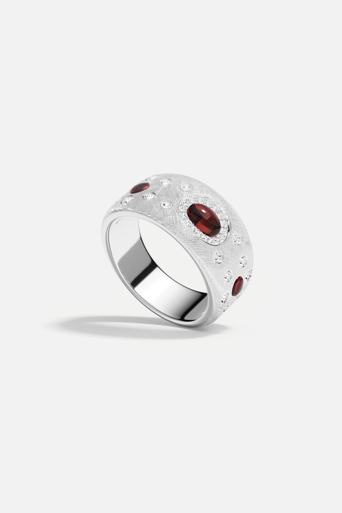 Bague APM, finition rhodium et éclats rouges, une élégance sculpturale et audacieuse.