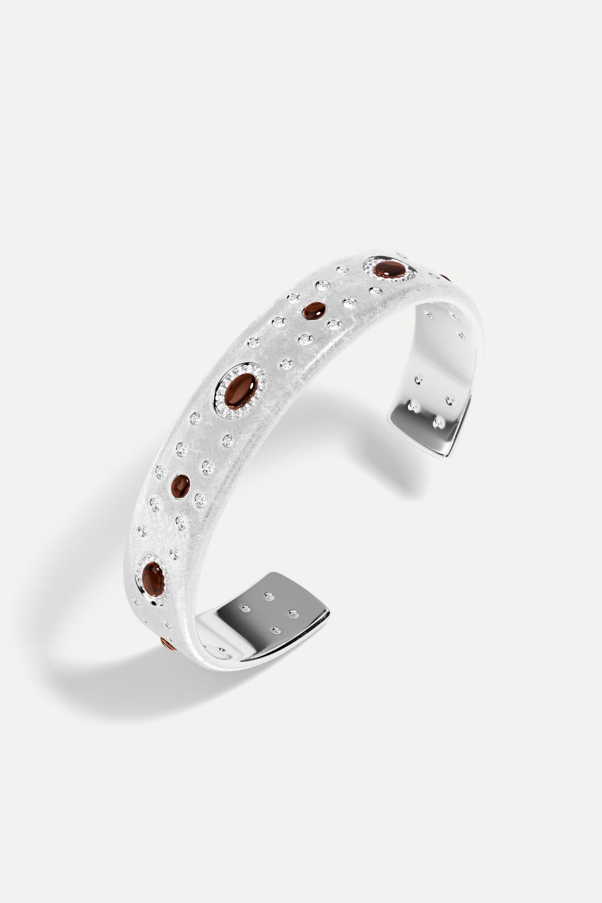 Bracelet APM en finition rhodium, éclats scintillants et touches ambrées, une élégance sculpturale intemporelle.