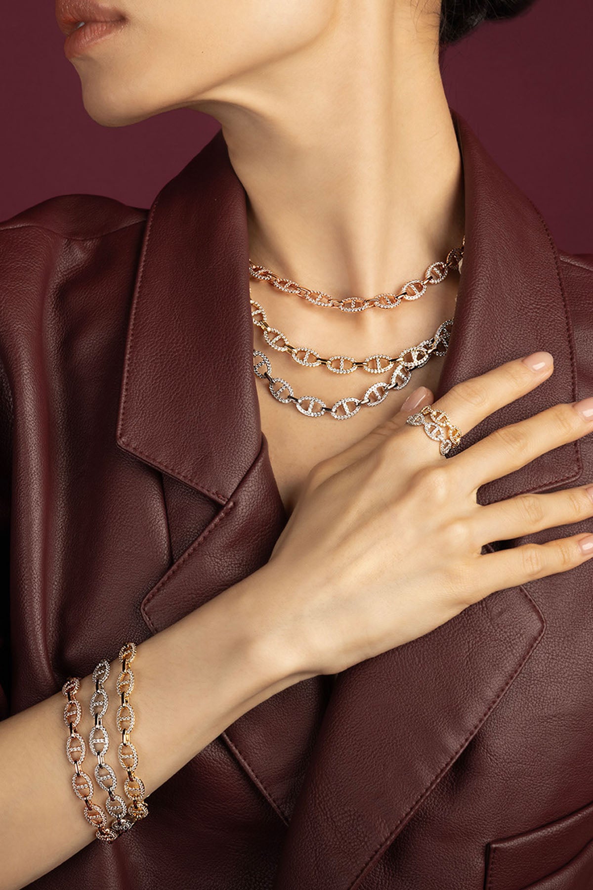 Femme portant les colliers, bracelets et bague APM Morse, allure audacieuse en cuir bordeaux.