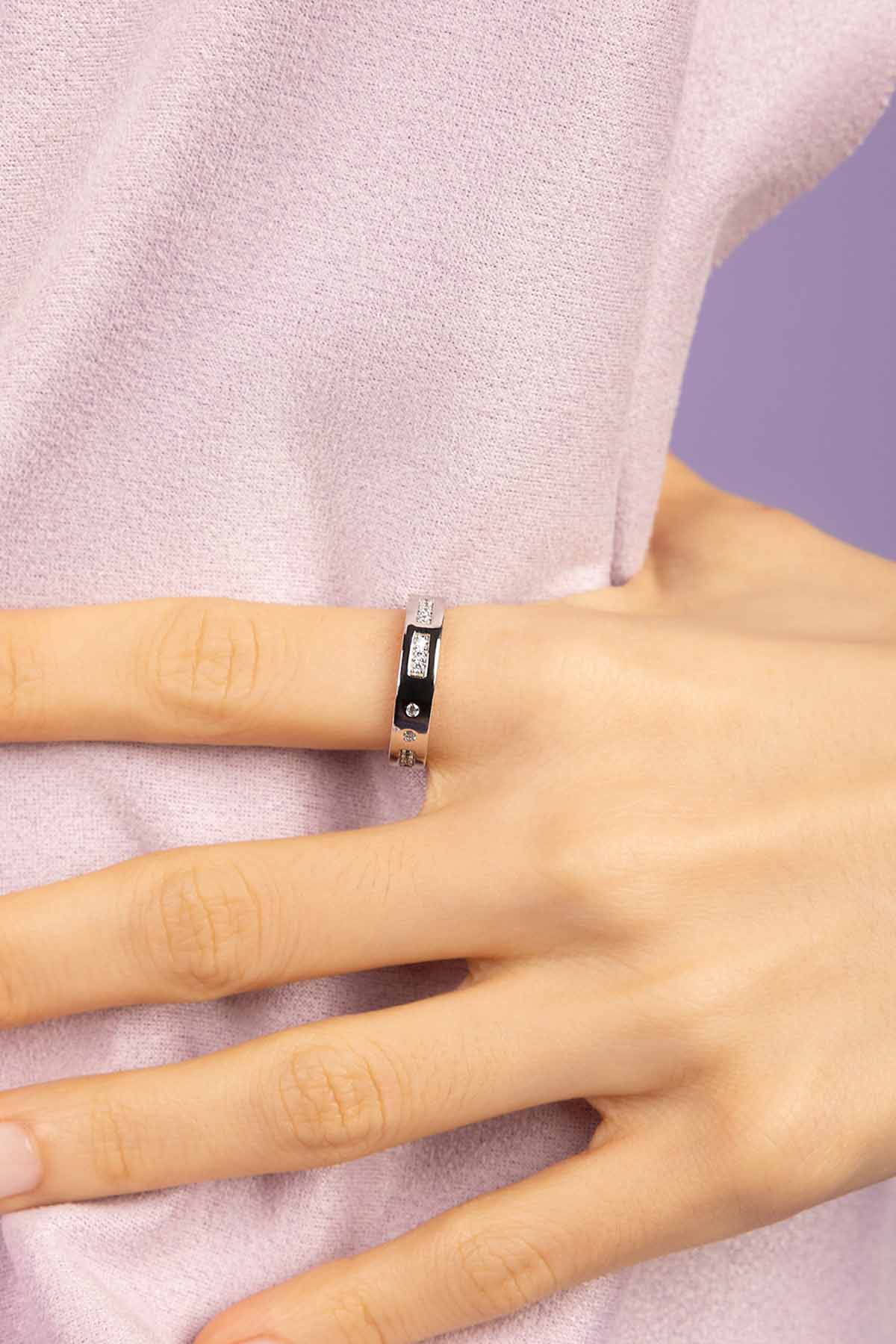 Silver ring on a person's finger against a white background