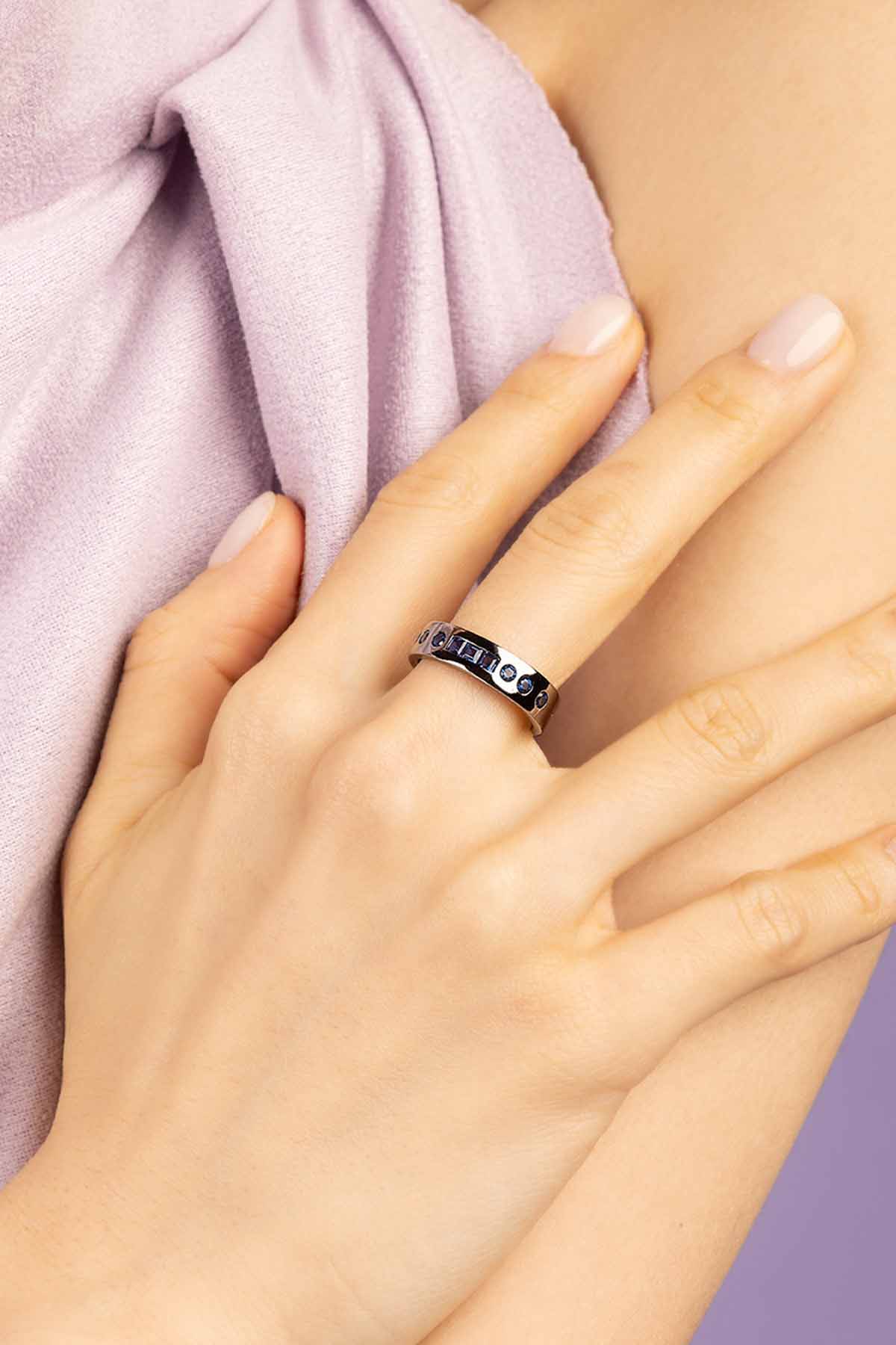 Hand wearing a silver ring with a white fur background