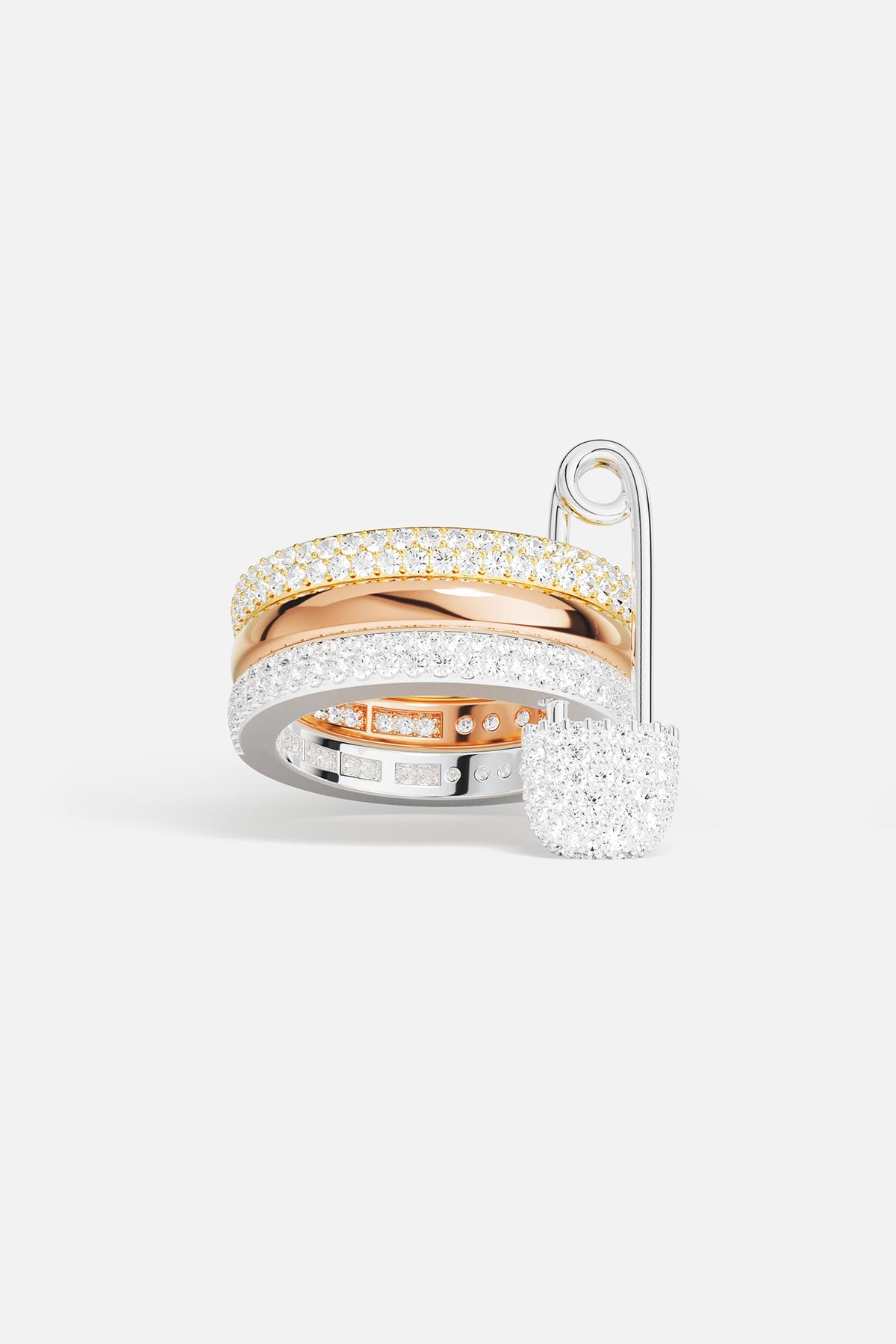 Rings APM Monaco fashion jewelry: a white, triple-hoop safety-pin ring with pavé cubic zirconia, paired with two additional cubic zirconia rings.