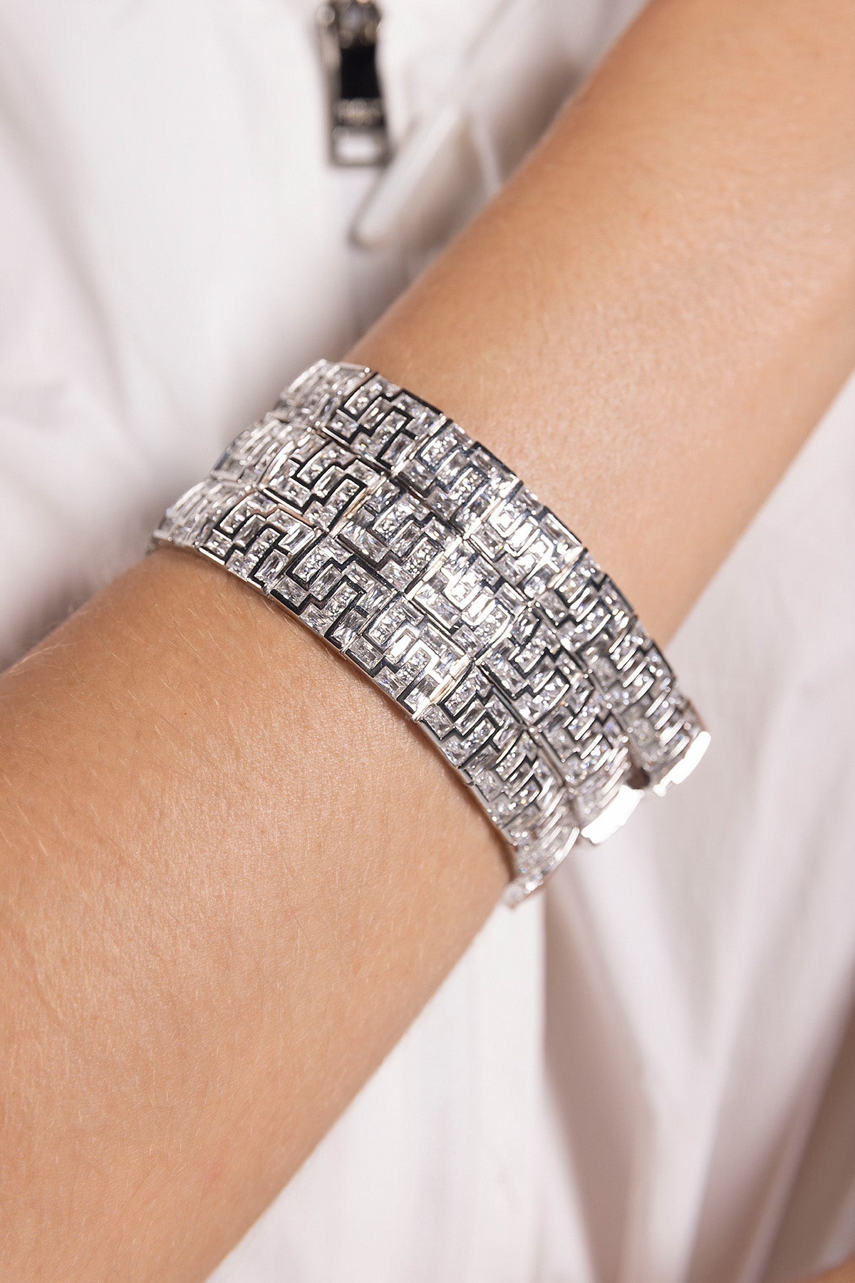APM MONACO chunky silver bracelet on a wrist with a white background