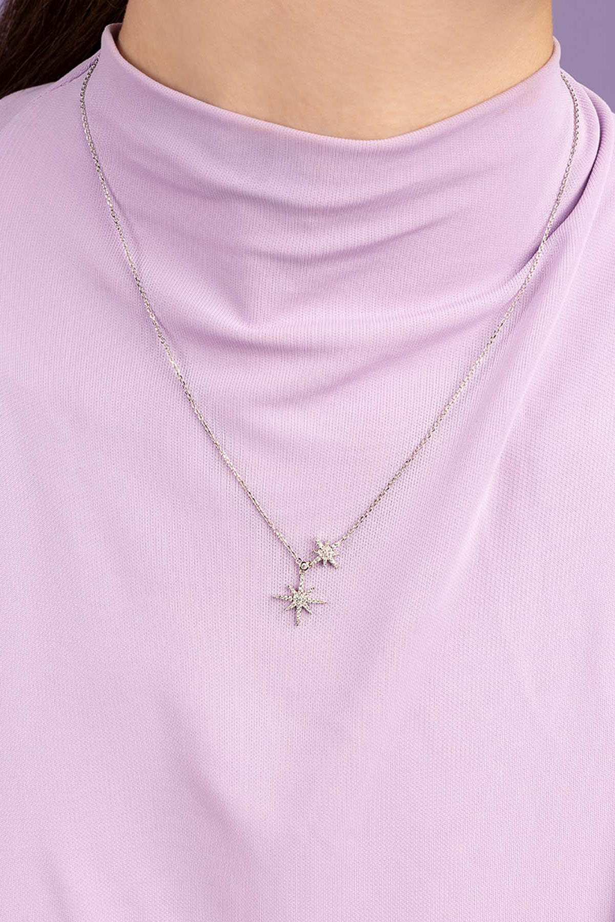 Necklaces APM Monaco, a silver-tone necklace with two star-shaped charms encrusted with small gems on a delicate chain.