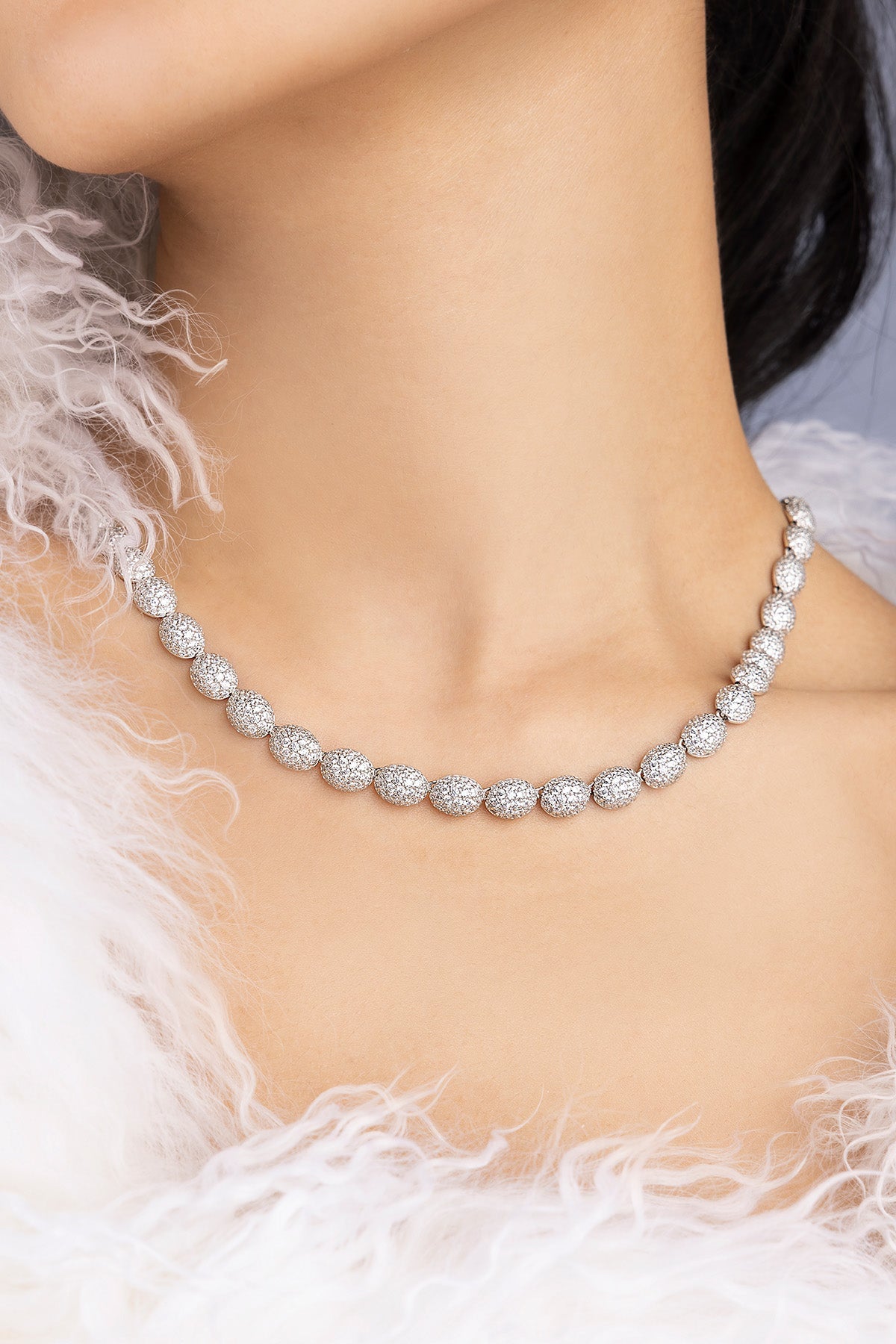 Necklace on neck with a white feathered garment