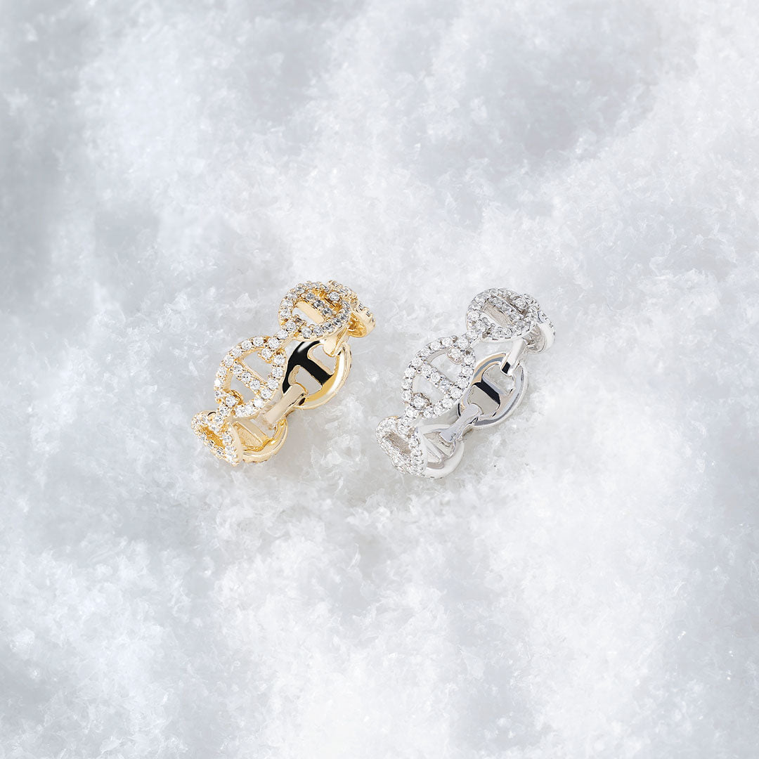 APM MONACO yacht club rings on snowy surface, one in silver and one in yellow gold