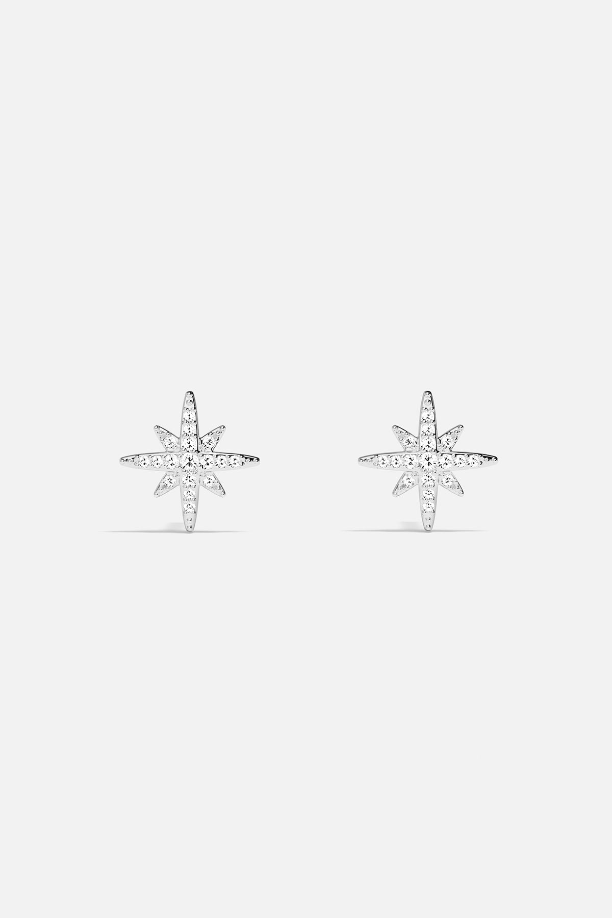 Earrings APM Monaco: silver starburst stud earrings with white stones.